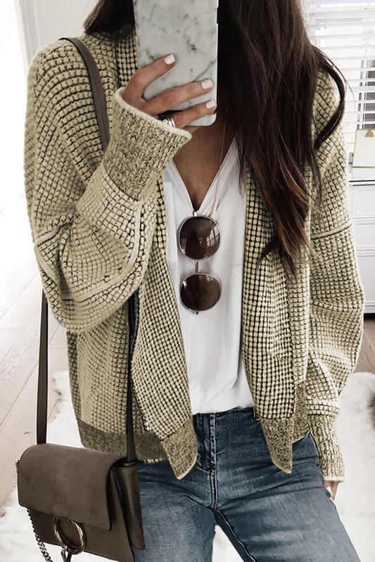 Aprikosenfarbene karierte strickjacke mit kontrastbesatz und offener vorderseite