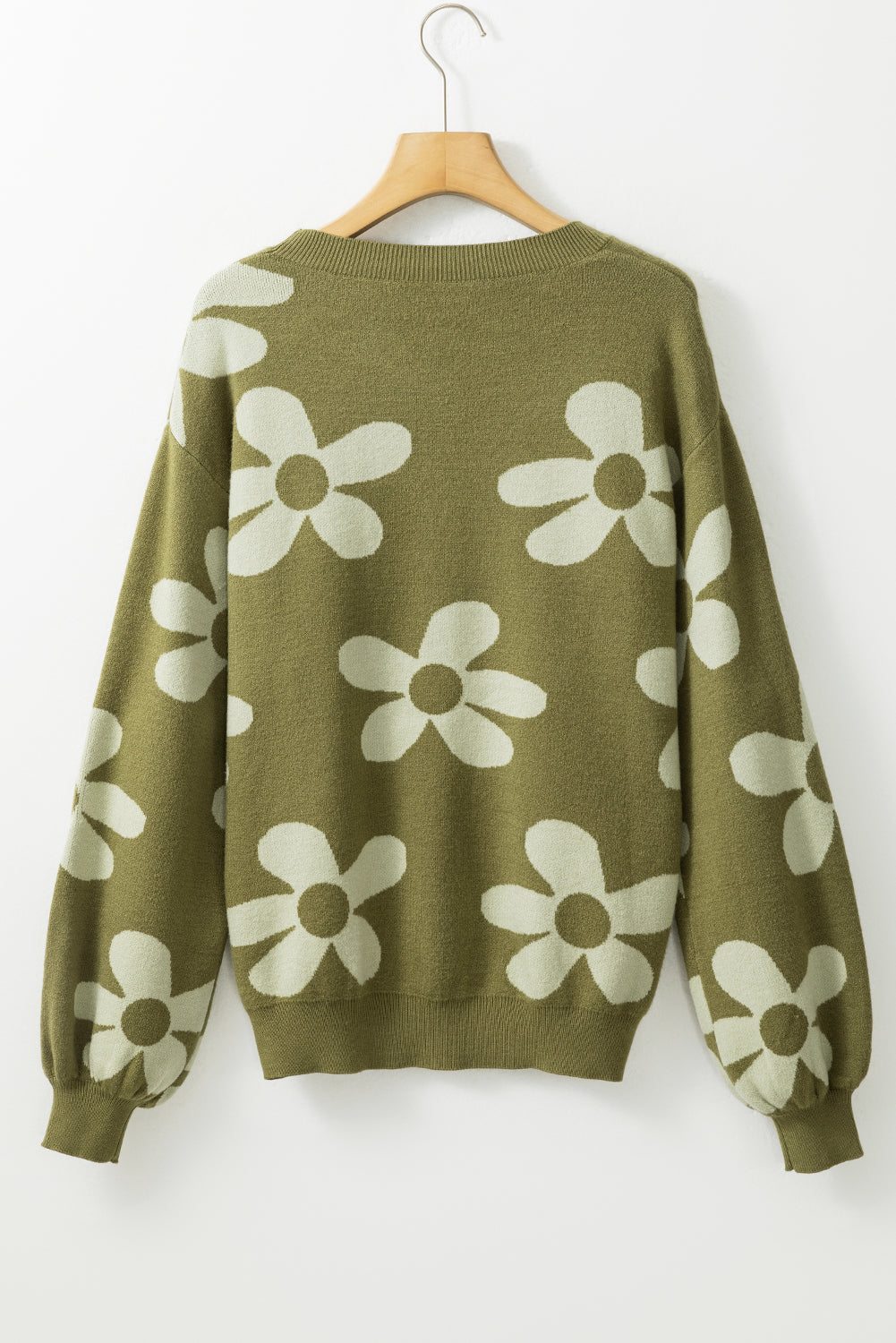 Spinatgrüner pullover mit großer blume und rippstrickmuster