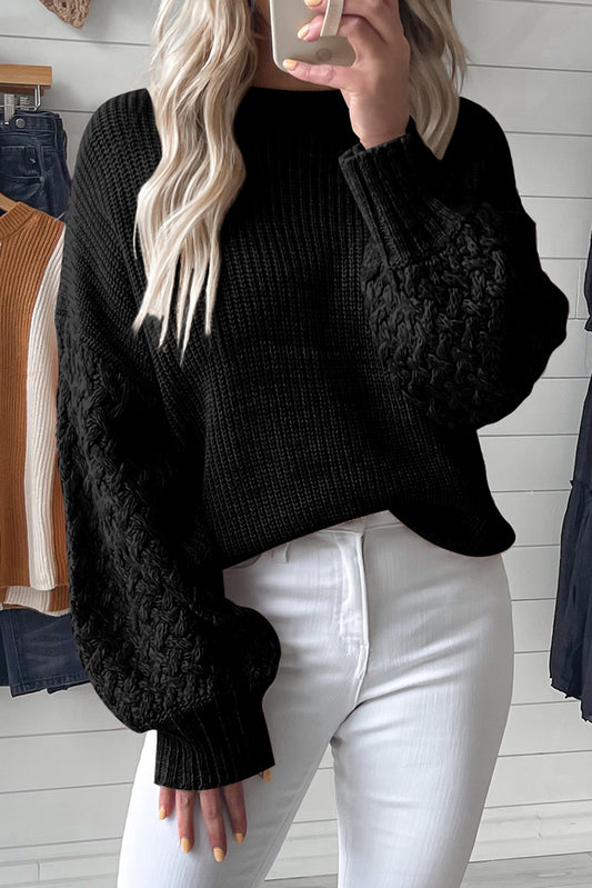 Schwarzer pullover mit zopfstrickärmeln und hängeschultern