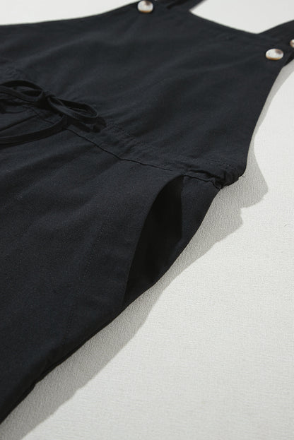 Schwarzer overall mit geknöpften riemen und kordelzug
