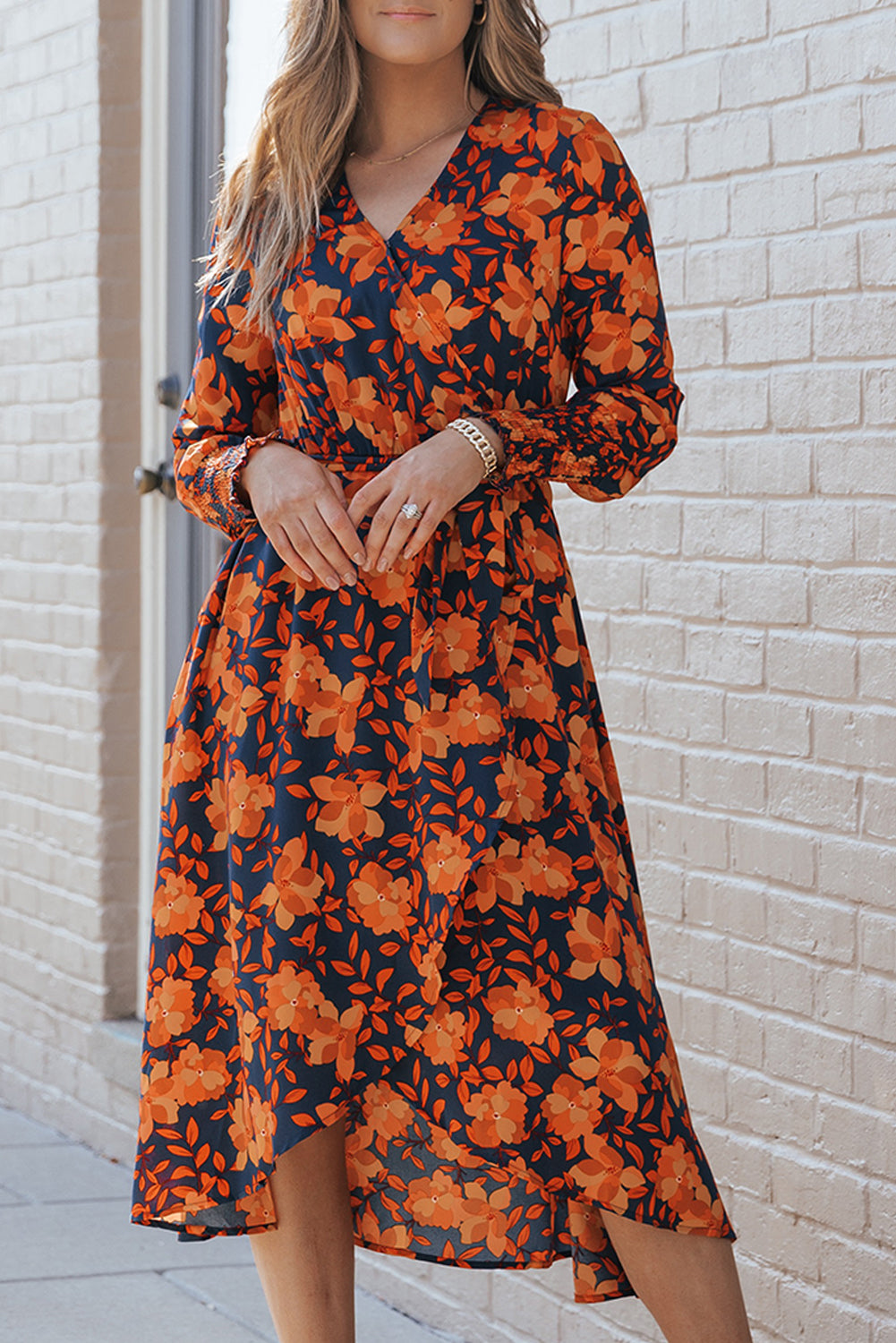 Orangefarbenes kleid mit gürtel und blumenmuster und faux wrap