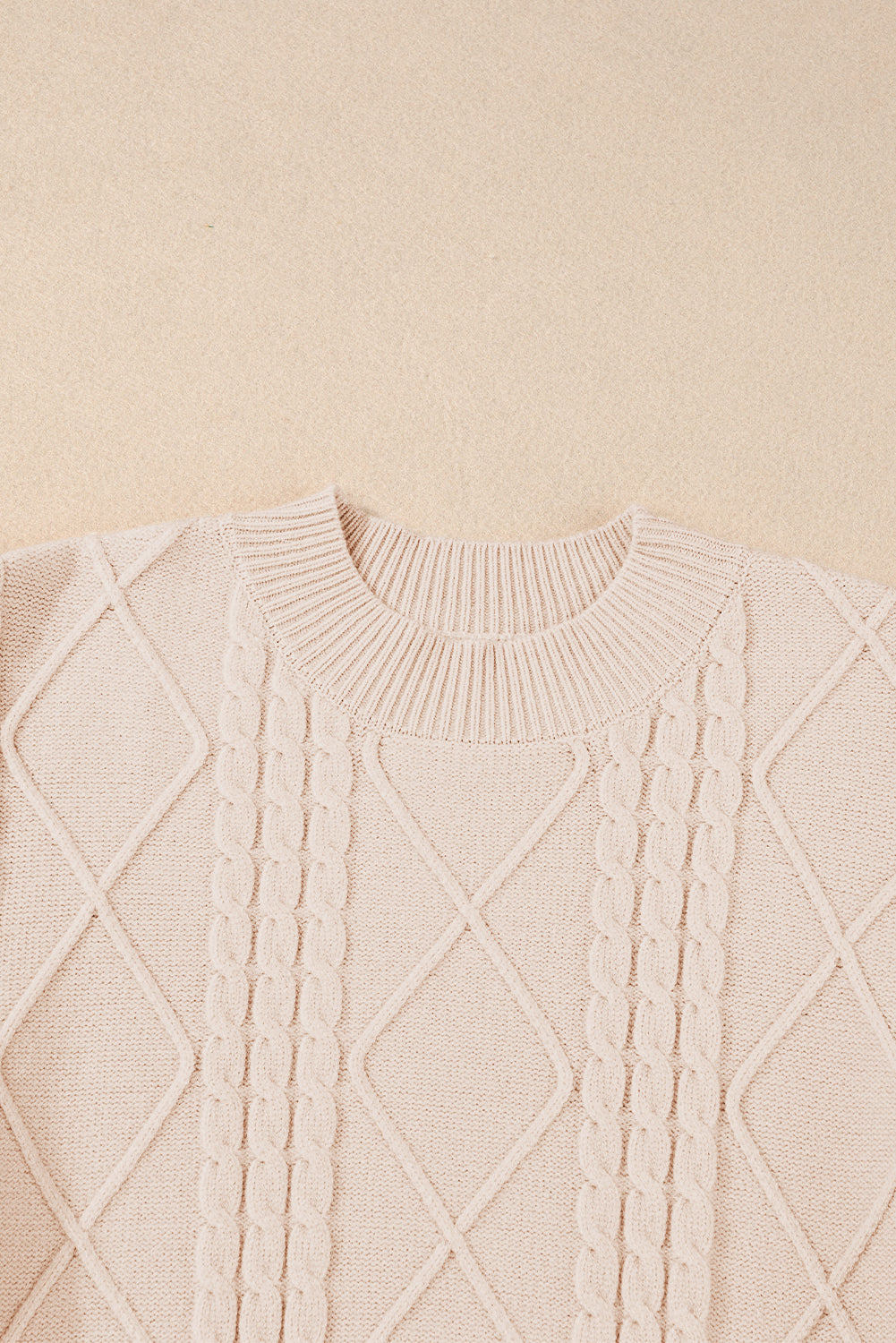 Pergamentfarbener kabelstrickpullover mit rollkragen und langen ärmeln