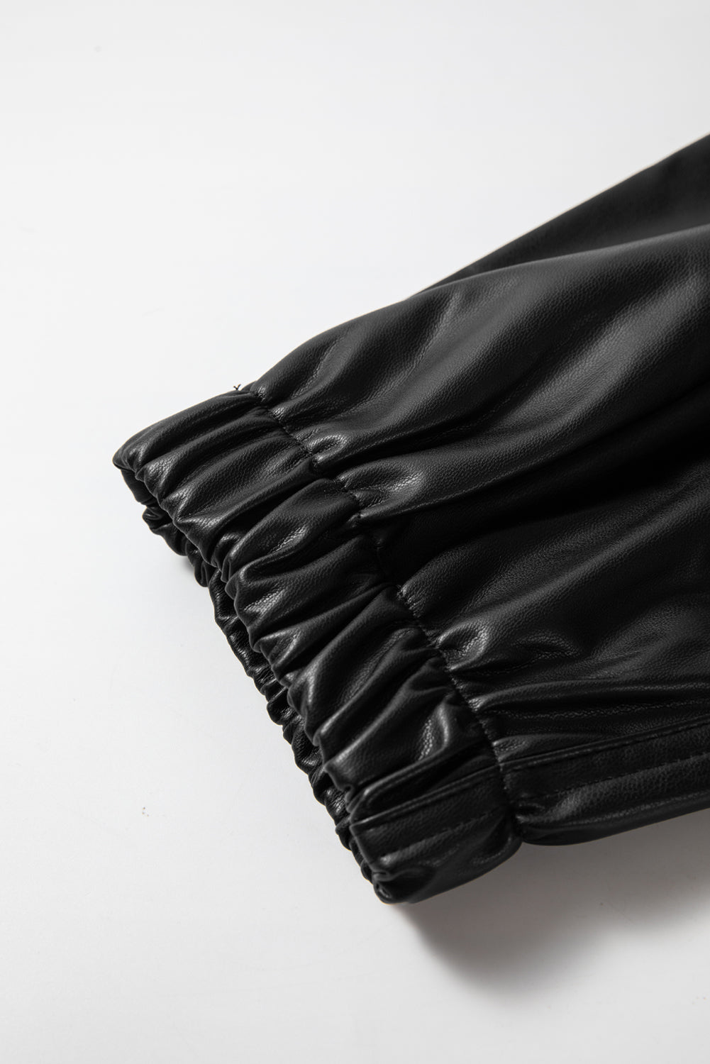 Schwarze kunstleder-jogginghose mit gesmokter taille und kordelzug