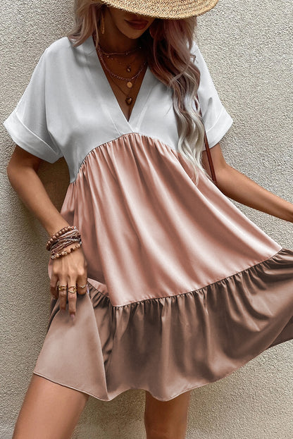 Helles französisches beige dreifarbiges kleid mit v-ausschnitt und gefalteten manschetten