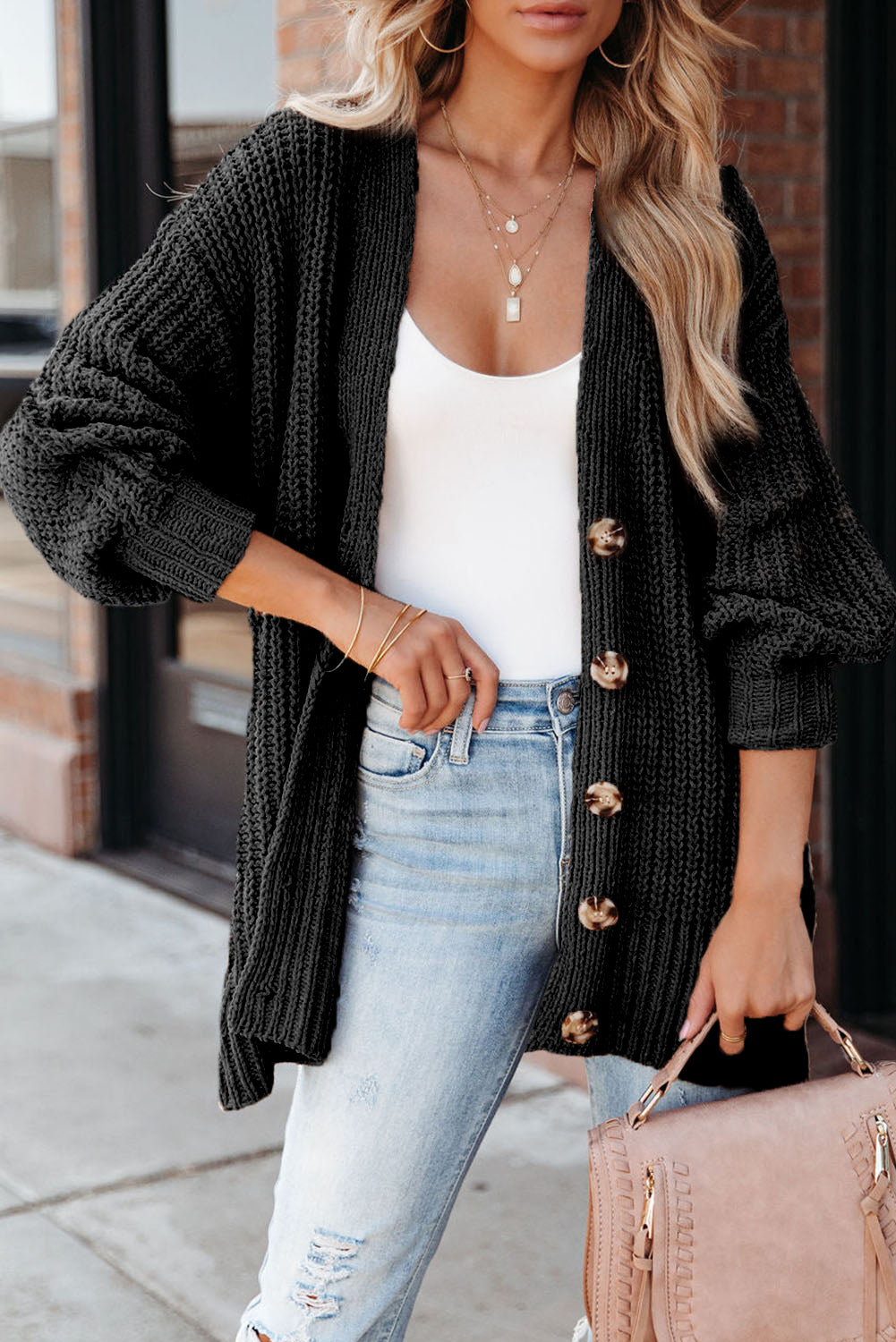 Schwarzer strickcardigan mit knöpfen an der vorderseite und hängeschultern
