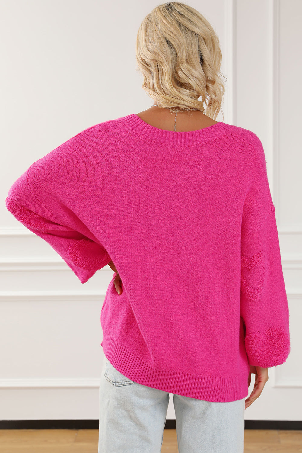 Rosenroter, perlenverzierter pullover mit v-ausschnitt und flauschigen herzen
