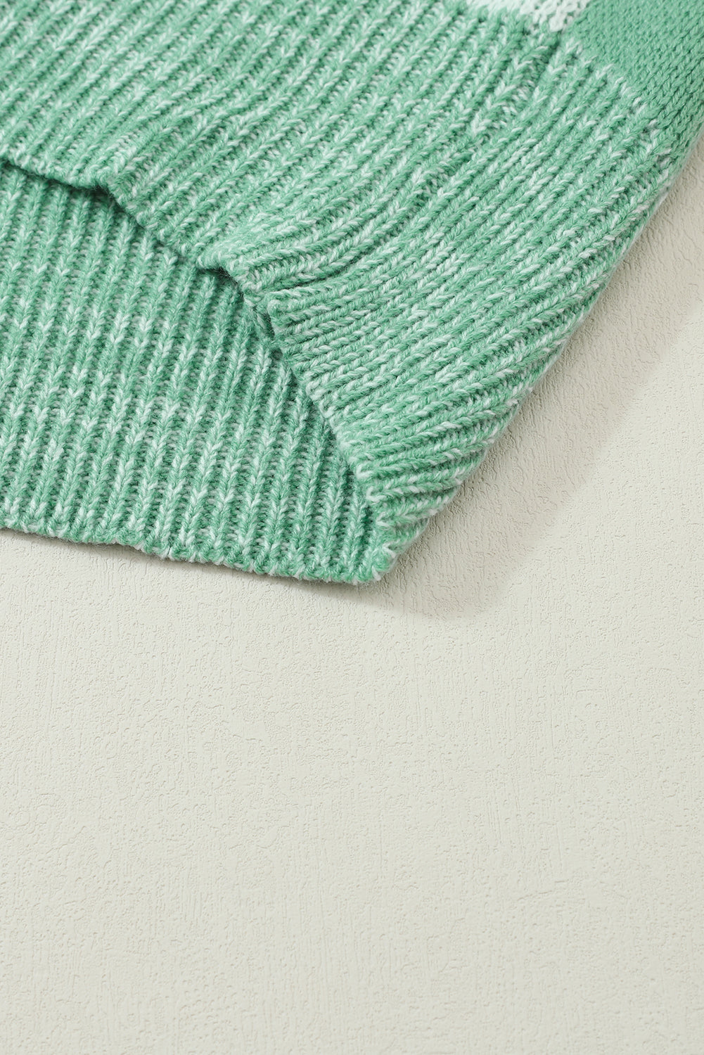 Mintgrüner pullover mit karomuster und schultertaschen