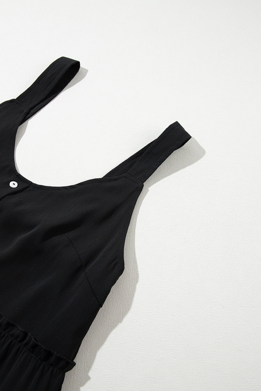 Schwarzes ärmelloses kleid mit v-ausschnitt und rüschenbesatz