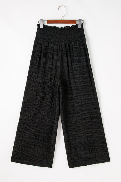 Schwarze strukturierte hose mit breiter gesmokter taille und loser hose