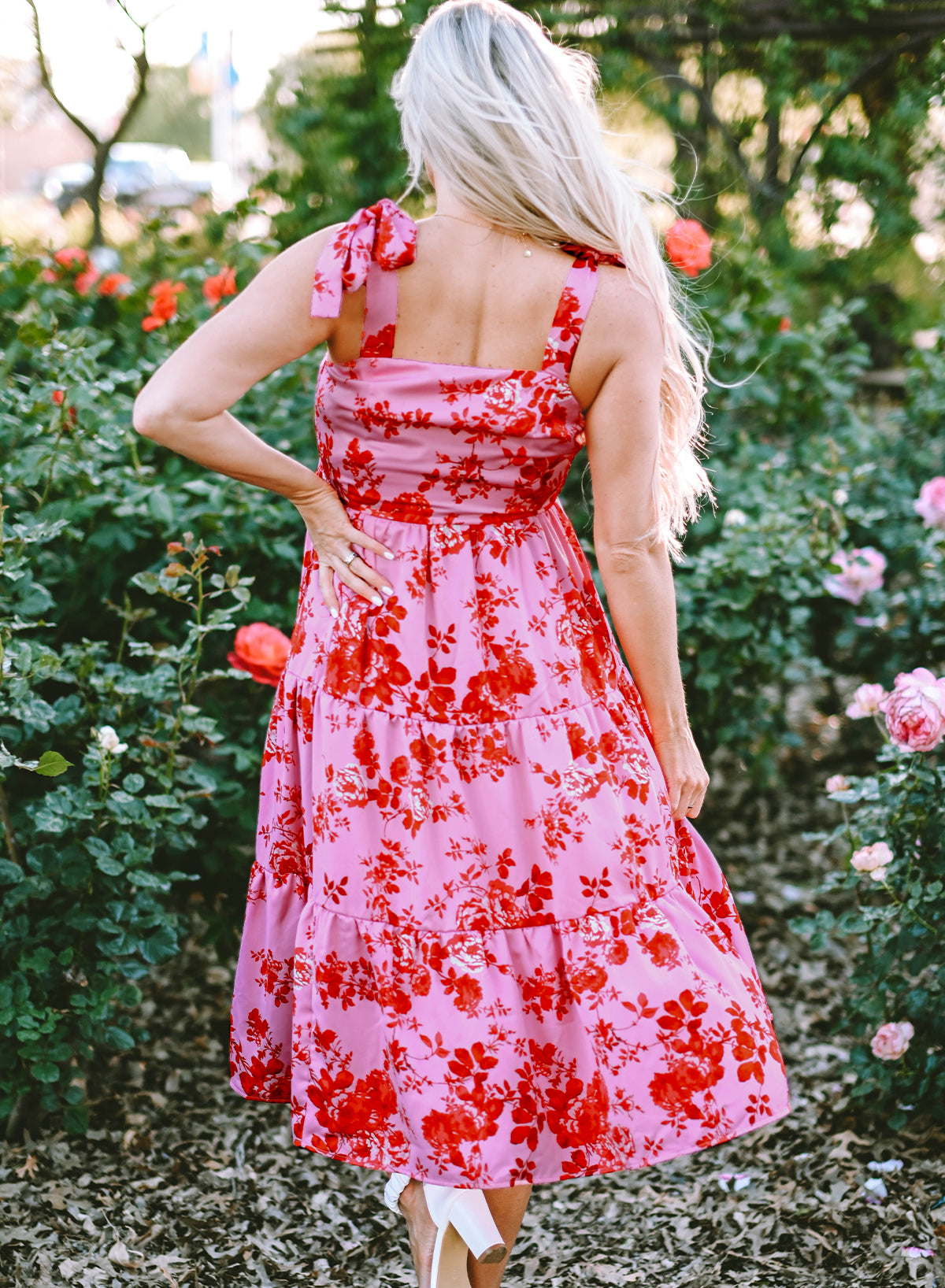 Rosa kleid mit gestuften blumenträgern und krawattenschultern