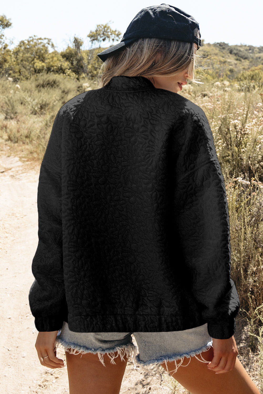 Schwarze gesteppte jacke mit blumenmuster