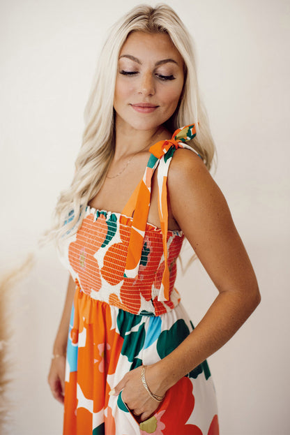 Orangefarbenes maxikleid mit selbstgebundenen trägern und gesmokter oberweite