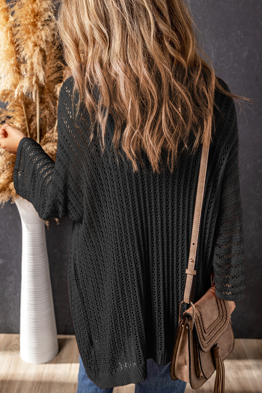 Schwarze strickjacke mit ausgehöhlten armbändern und ärmeln