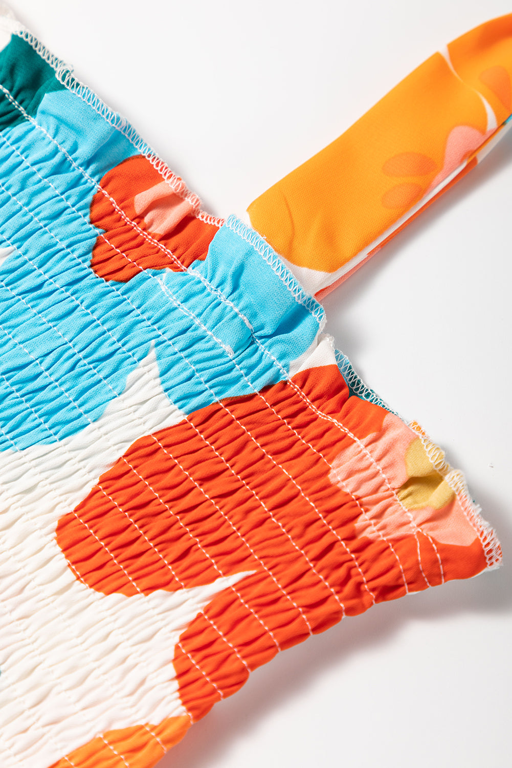 Orangefarbenes maxikleid mit selbstgebundenen trägern und gesmokter oberweite