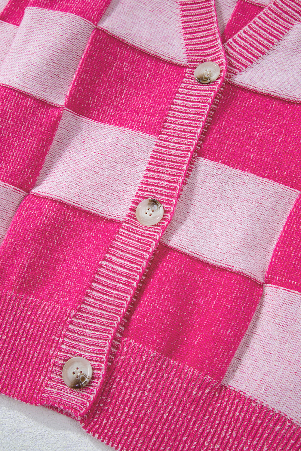 Rosa karierte strickjacke mit v-ausschnitt und geknöpften schultern