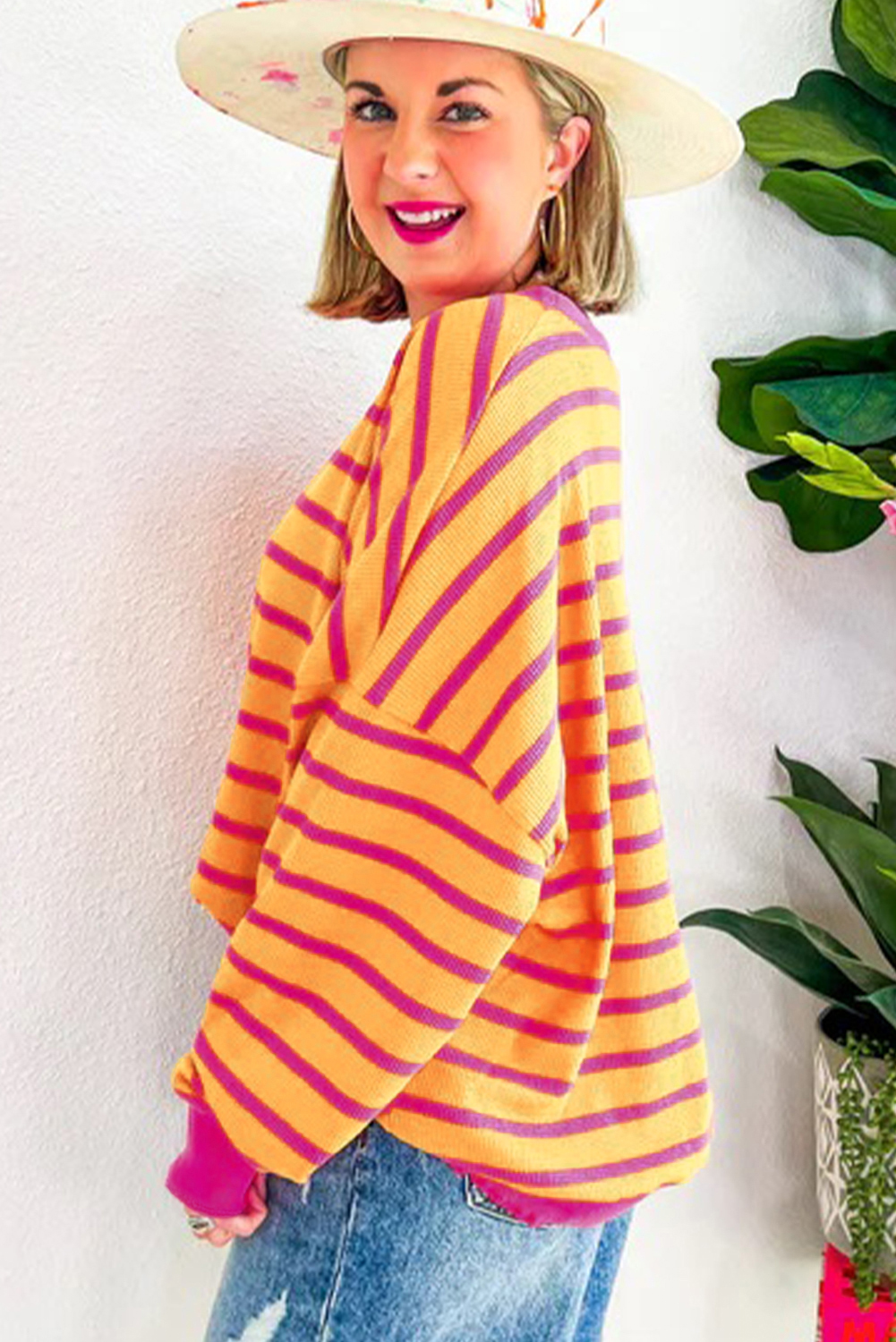 Orangefarbener gestreifter pullover mit rundhalsausschnitt und losen schultern