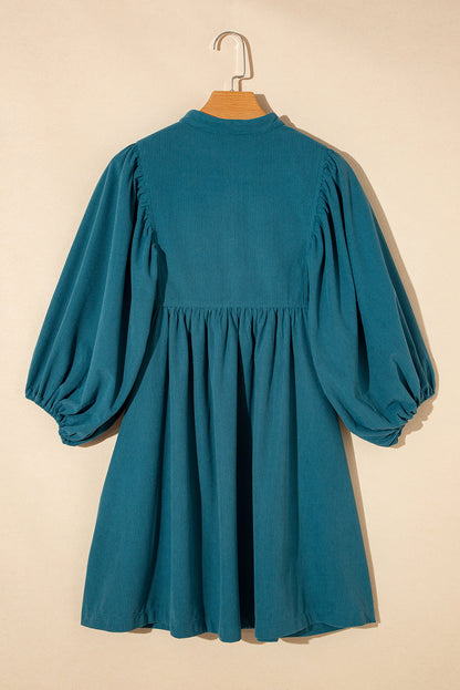 Blaues cord-knopf-kleid mit empire-taille und armband-ärmeln