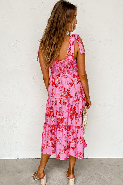 Rosa kleid mit gestuften blumenträgern und krawattenschultern