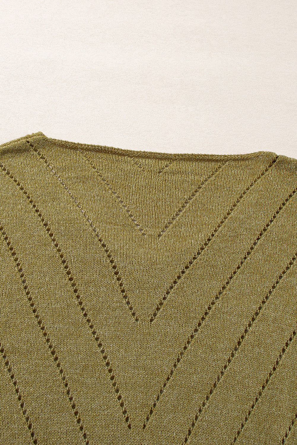 Salbeigrüner pullover mit v-ausschnitt und tropfenschulter in ösenform