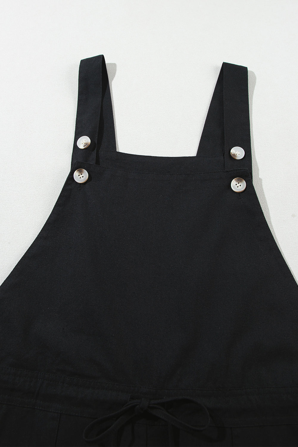 Schwarzer overall mit geknöpften riemen und kordelzug