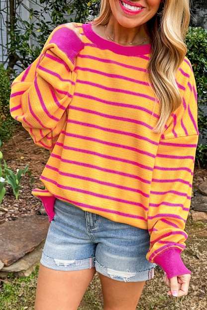 Orangefarbener gestreifter pullover mit rundhalsausschnitt und losen schultern