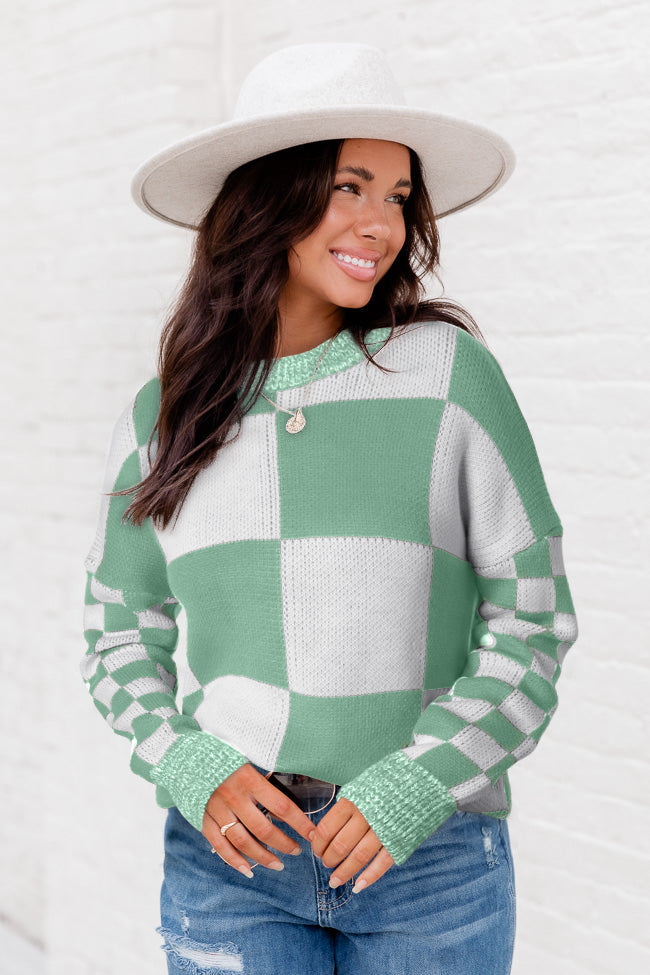 Mintgrüner pullover mit karomuster und schultertaschen