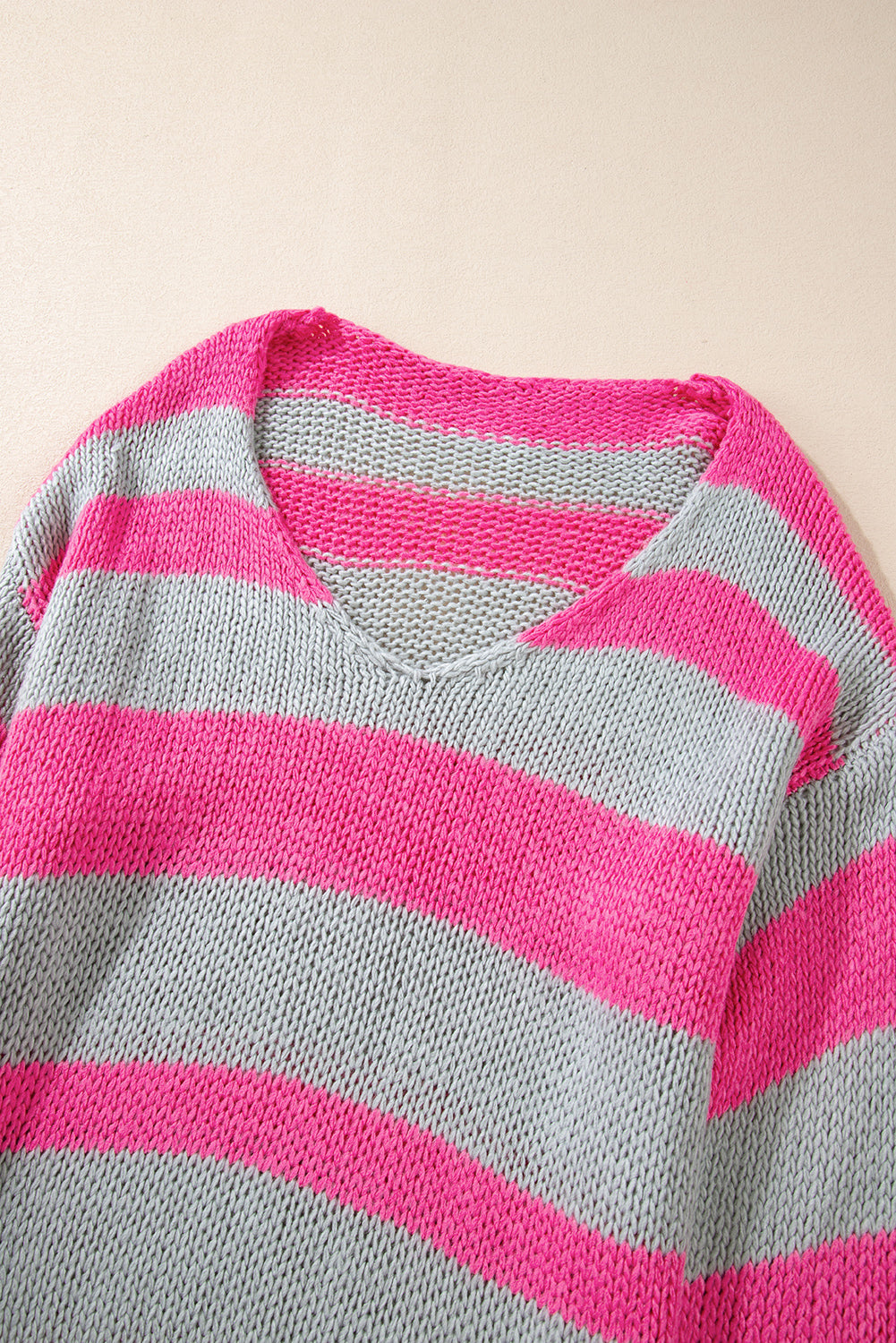 Rosa gestreifter colorblock-strickpullover mit v-ausschnitt und lockerer passform