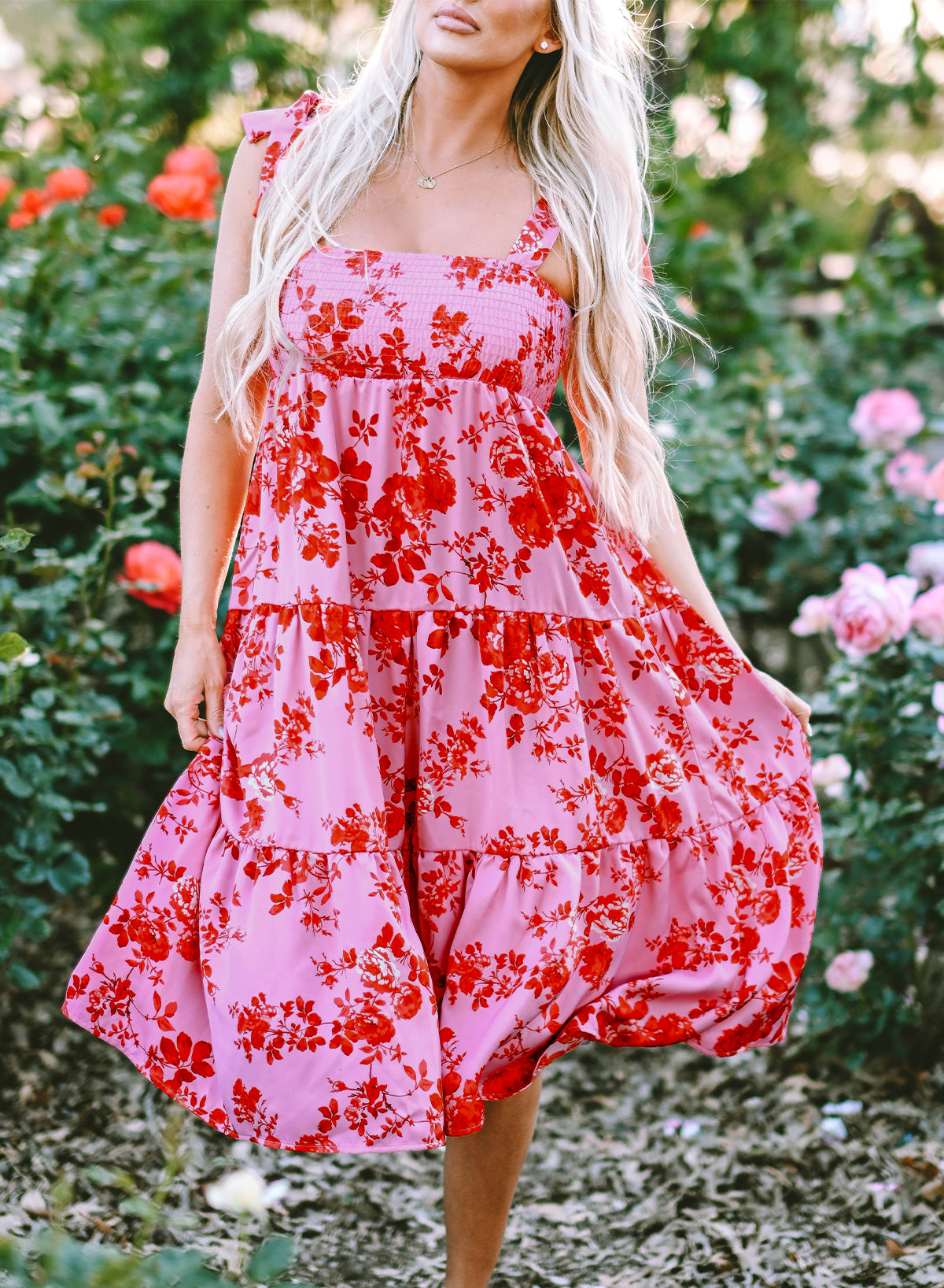 Rosa kleid mit gestuften blumenträgern und krawattenschultern
