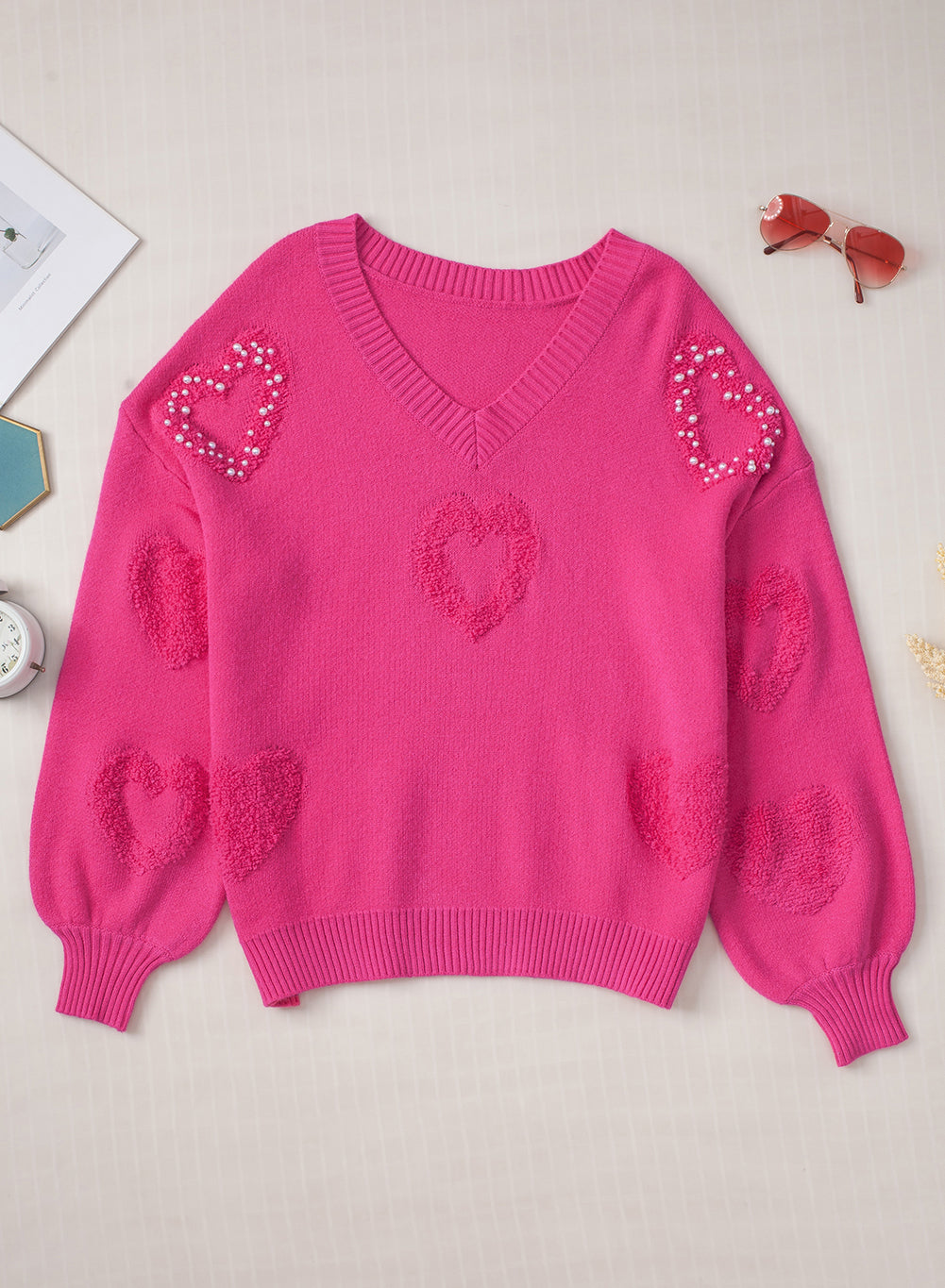 Rosenroter, perlenverzierter pullover mit v-ausschnitt und flauschigen herzen