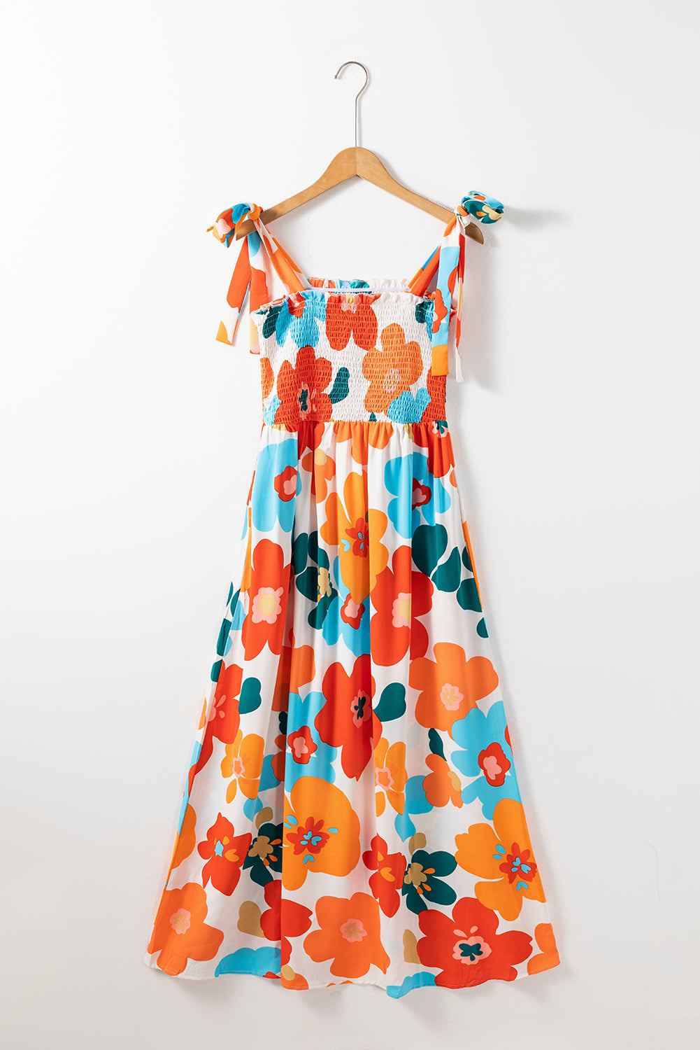 Orangefarbenes maxikleid mit selbstgebundenen trägern und gesmokter oberweite