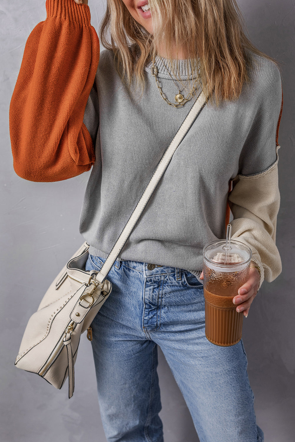 Grauer colorblock-pullover mit gerippten ärmeln und zierleisten
