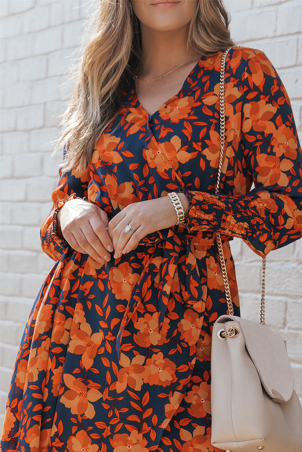 Orangefarbenes kleid mit gürtel und blumenmuster und faux wrap
