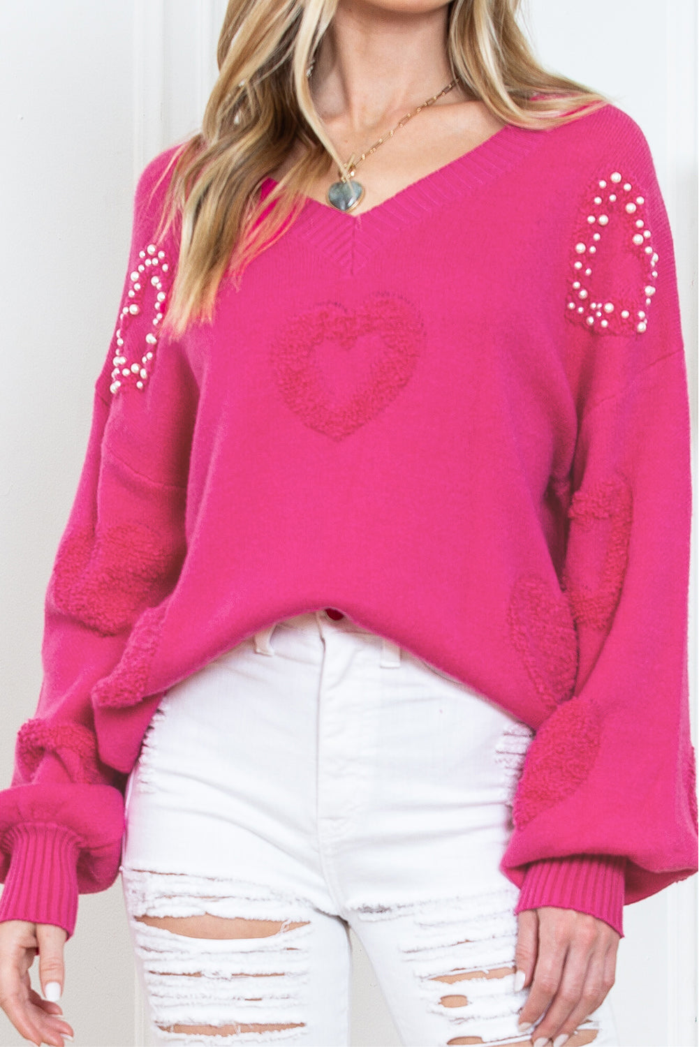 Rosenroter, perlenverzierter pullover mit v-ausschnitt und flauschigen herzen
