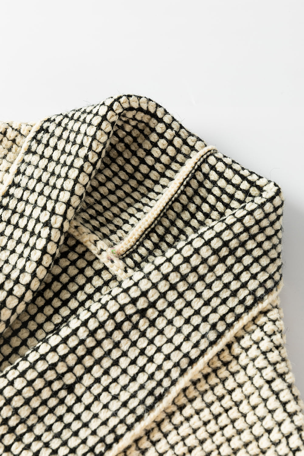 Aprikosenfarbene karierte strickjacke mit kontrastbesatz und offener vorderseite