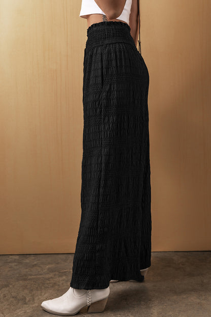 Schwarze strukturierte hose mit breiter gesmokter taille und loser hose