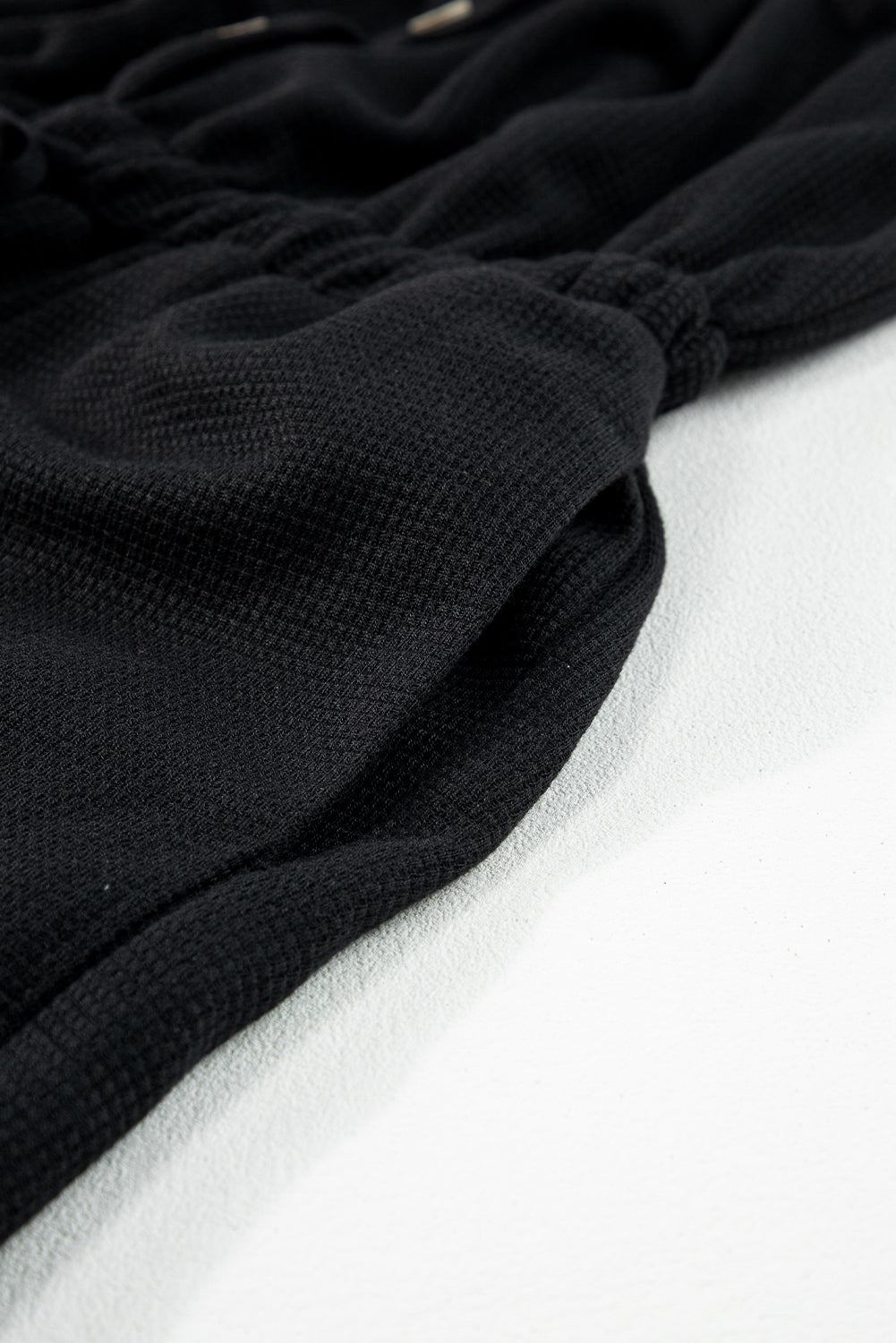 Schwarzer jumpsuit mit geknoteten trägern und strukturiertem kordelzug