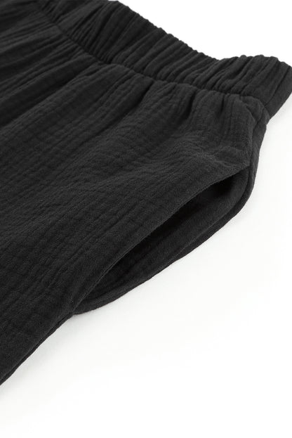 Schwarze strukturierte hose mit hoher taille und gerafftem glockenboden