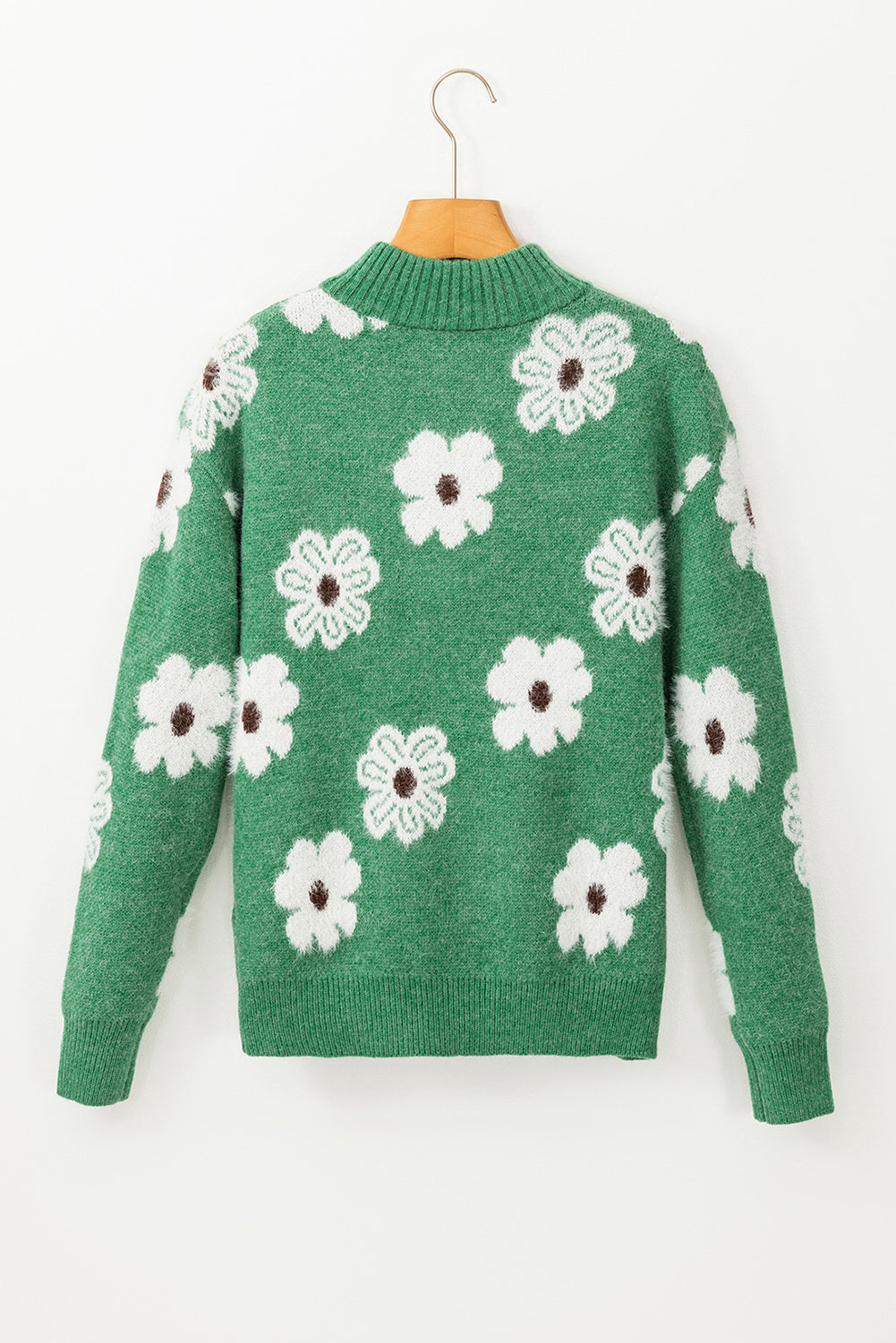 Grüner pullover mit floralem muster und halbem reißverschluss an der schulter