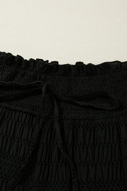 Schwarze strukturierte hose mit breiter gesmokter taille und loser hose