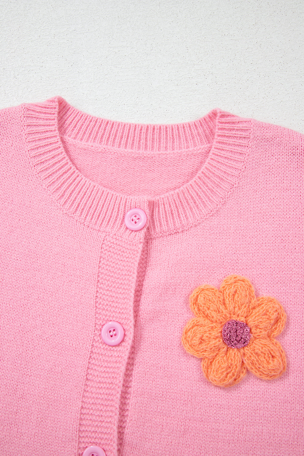 Rosa niedliche strickjacke mit blumenmuster und knopfleiste
