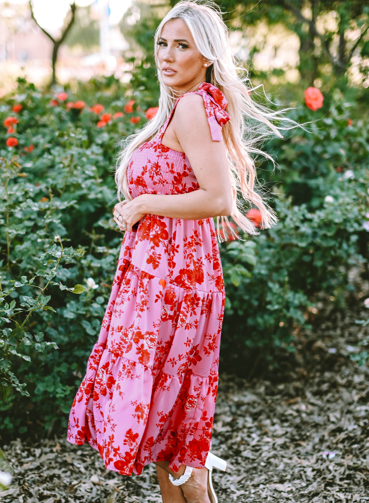 Rosa kleid mit gestuften blumenträgern und krawattenschultern