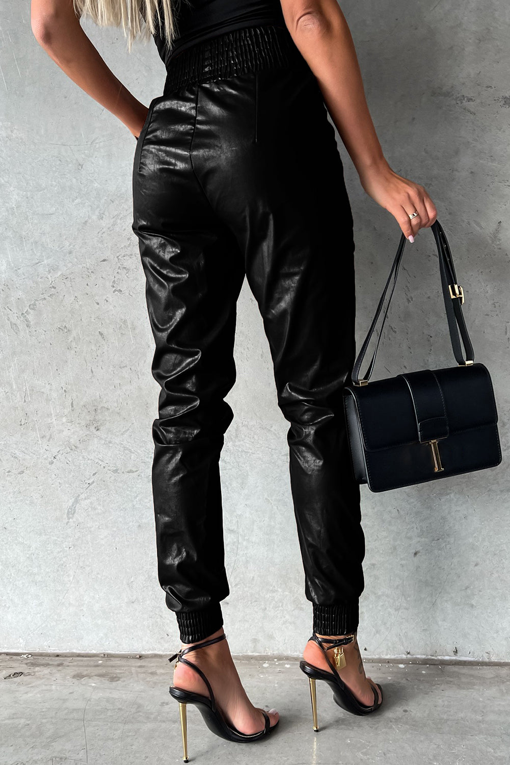 Schwarze gesmokte leder-skinny-hose mit hoher taille