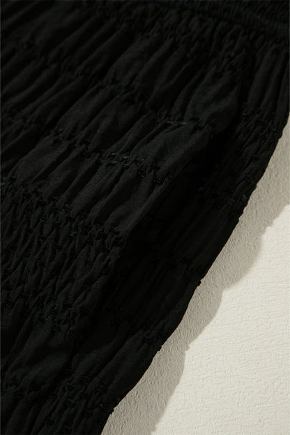 Schwarze strukturierte hose mit breiter gesmokter taille und loser hose