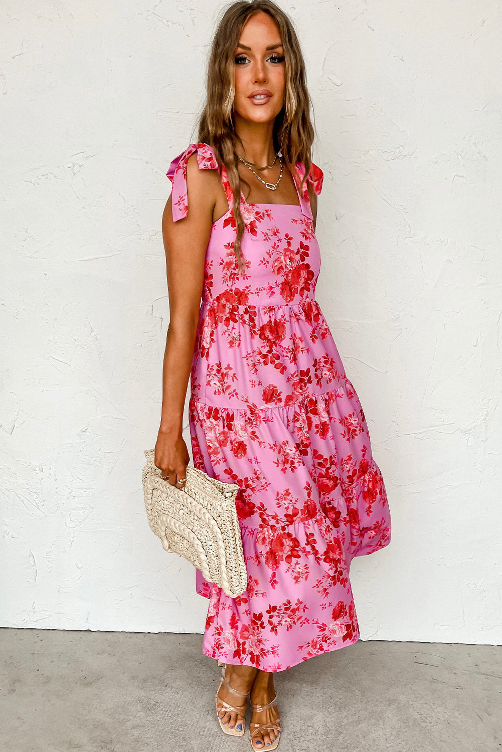 Rosa kleid mit gestuften blumenträgern und krawattenschultern