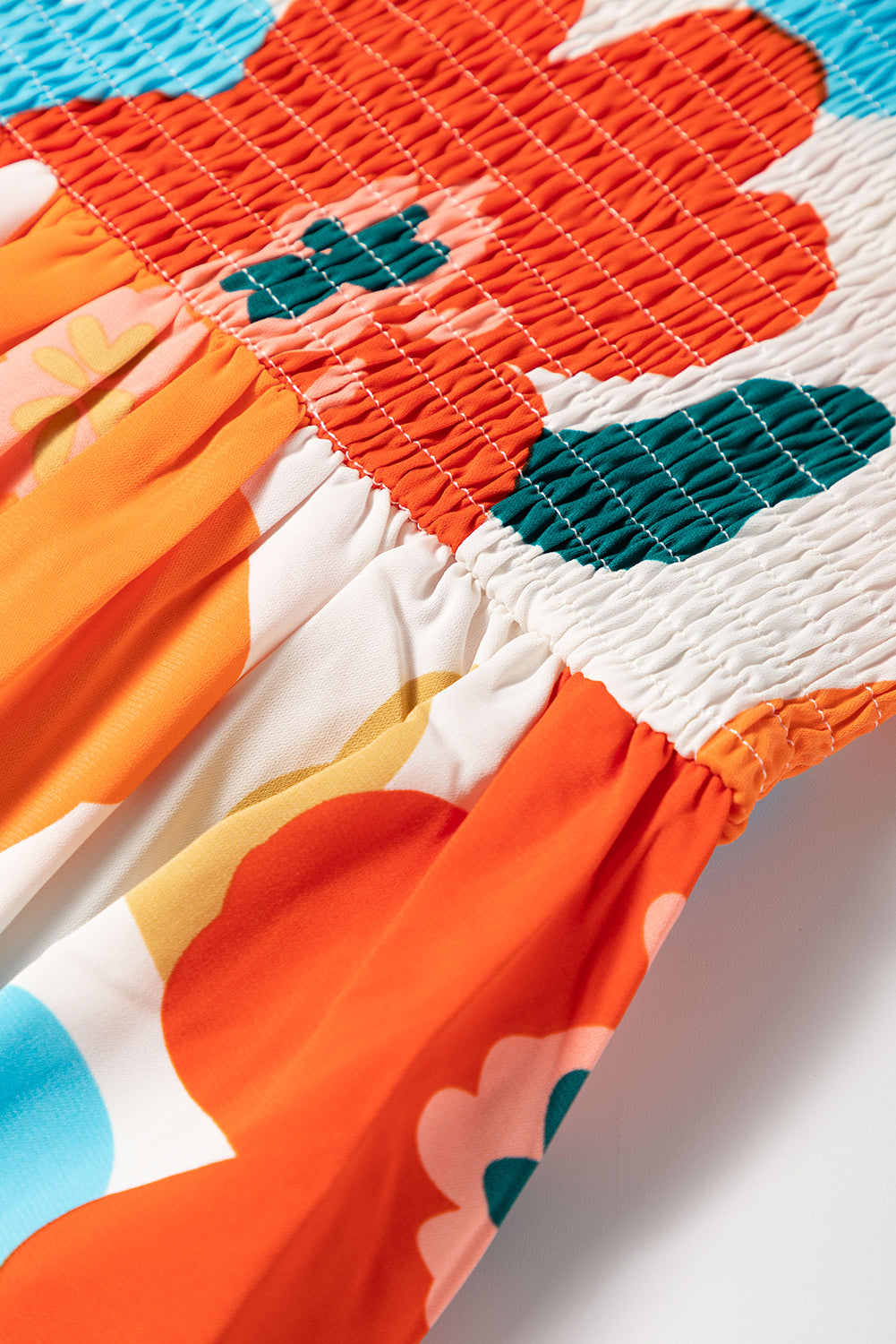 Orangefarbenes maxikleid mit selbstgebundenen trägern und gesmokter oberweite