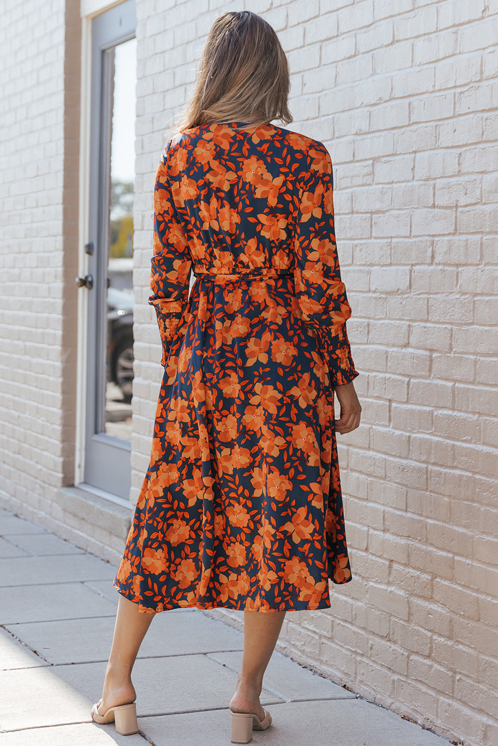 Orangefarbenes kleid mit gürtel und blumenmuster und faux wrap
