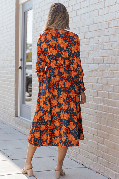 Orangefarbenes kleid mit gürtel und blumenmuster und faux wrap