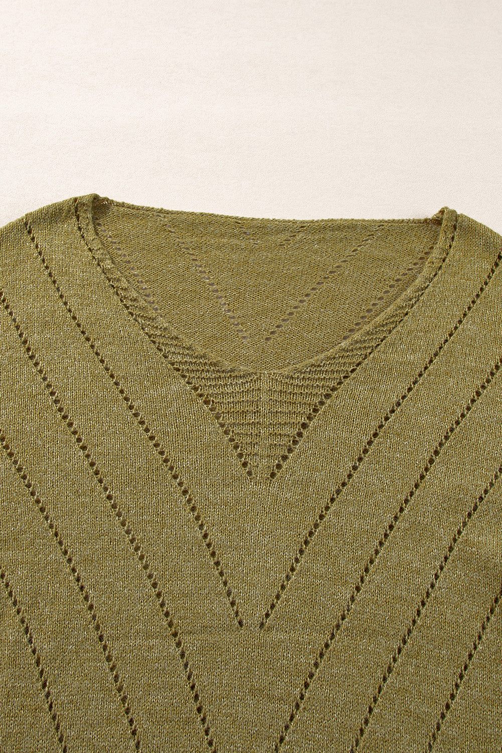 Salbeigrüner pullover mit v-ausschnitt und tropfenschulter in ösenform