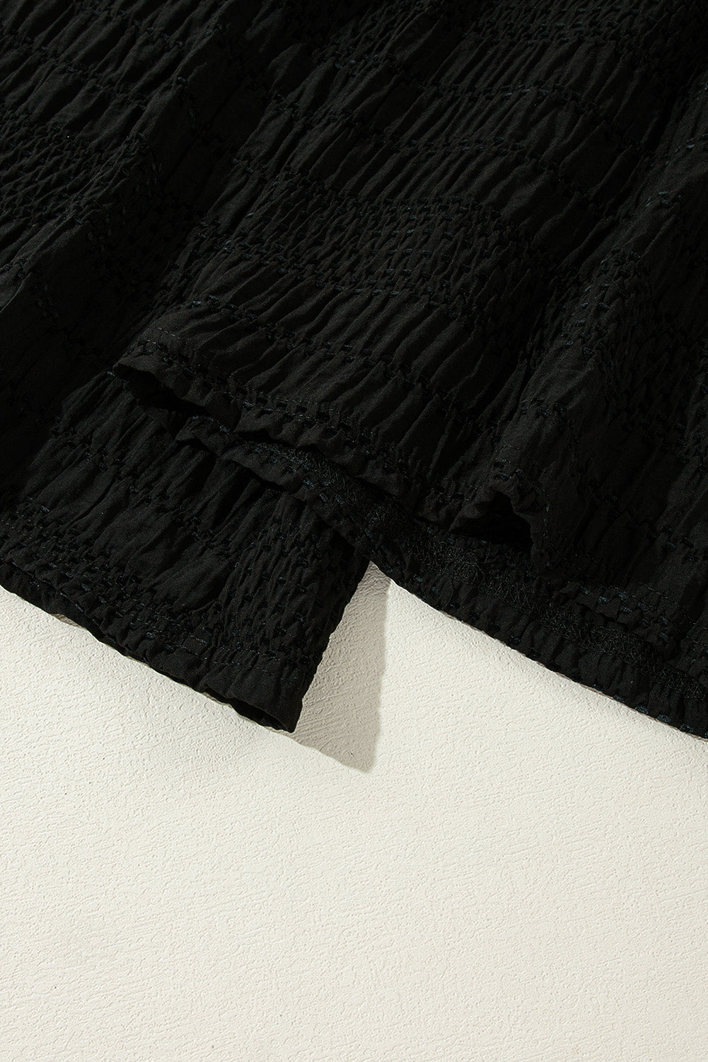 Schwarze strukturierte hose mit breiter gesmokter taille und loser hose