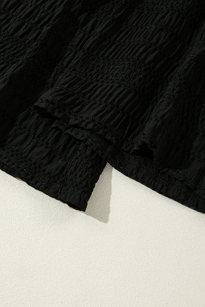Schwarze strukturierte hose mit breiter gesmokter taille und loser hose